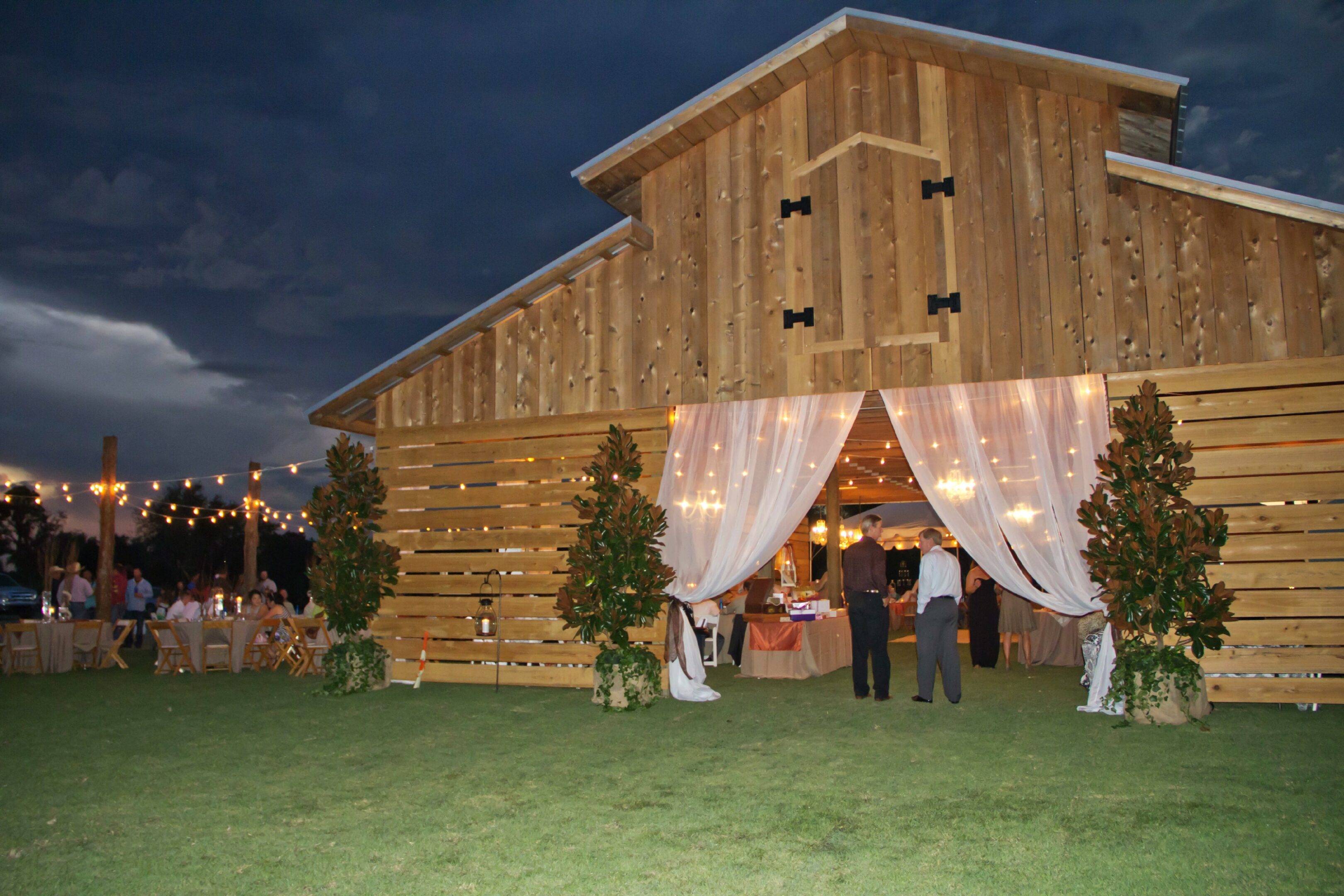 N. Wedding (416) (1) A group of people standing outside of a barn.