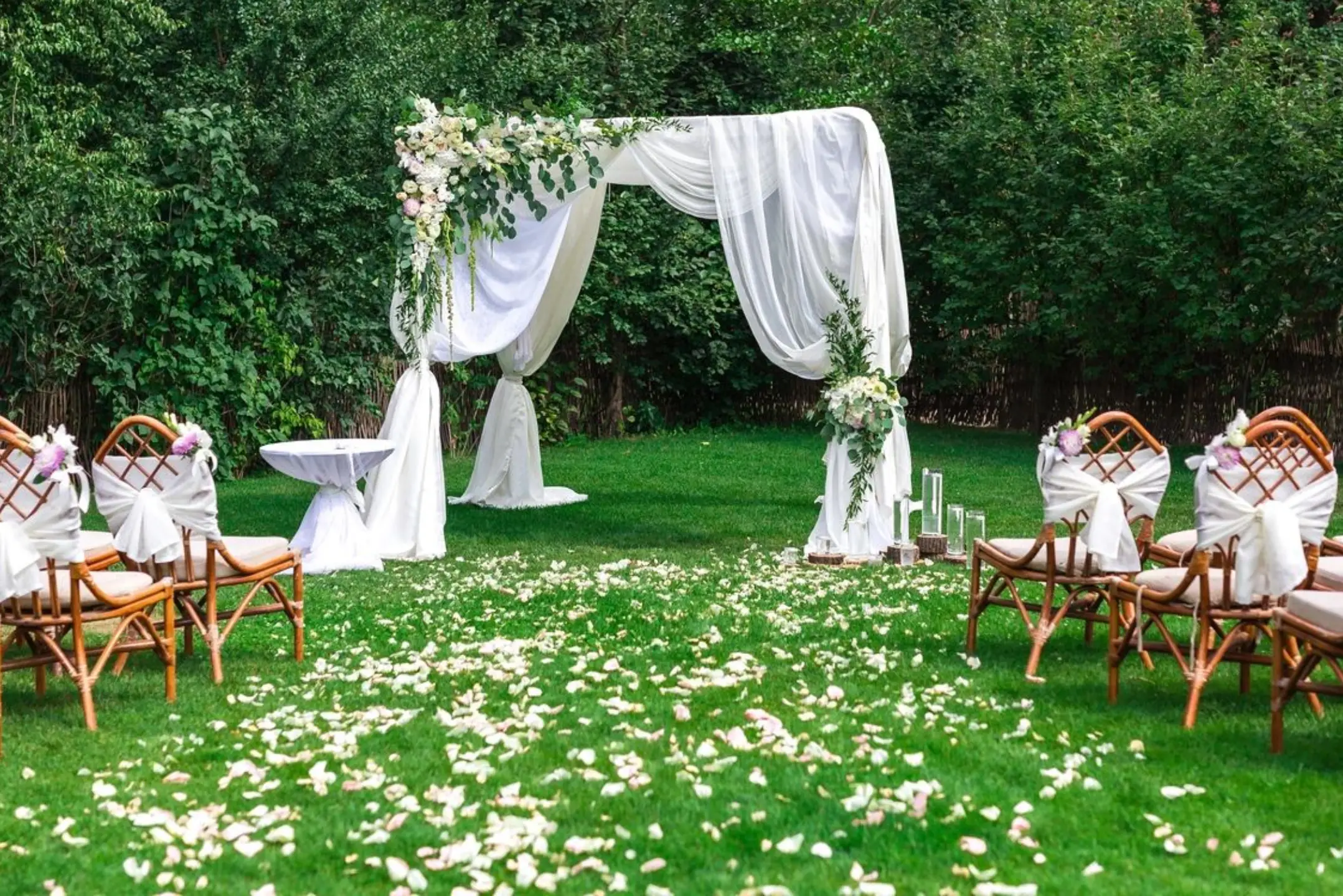 A wedding set up in the grass with flowers.