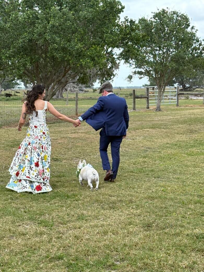 A man and woman walking with their dog.