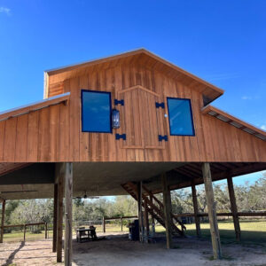 A large wooden building with two windows on the side.