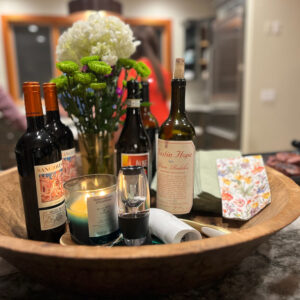 A wooden bowl with wine bottles and candles.