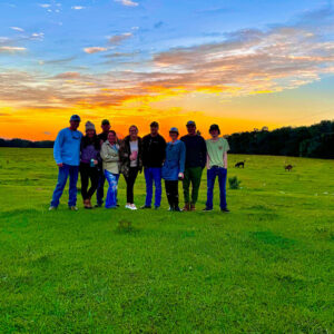 A group of people standing in the grass.