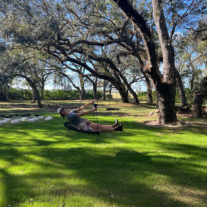 A man laying on the grass in front of some trees