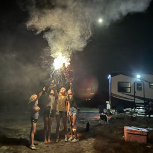 A group of people standing around a fire.